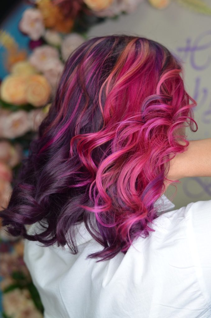 Păr ondulat, colorat în nuanțe de roz și violet.